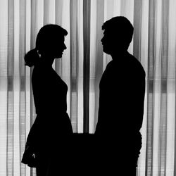 Silhouette people standing against curtain