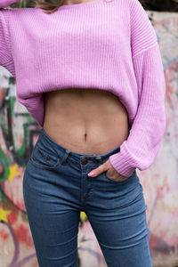 Midsection of woman standing on pink umbrella