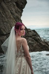 Portrait of woman standing by sea against sky