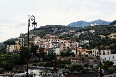 Houses in town against cloudy sky