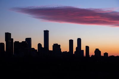 Silhouette buildings against sky during sunset