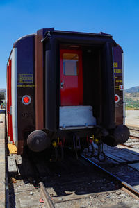 Train by railroad tracks against clear sky