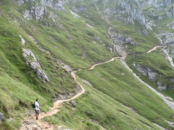 Mid distance view of male hiker standing on trail at mountain