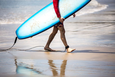 Surfer walking on beach