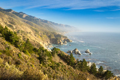 Scenic view of sea and mountains against sky