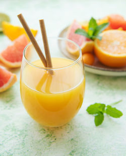 Glass of juice and fresh citrus fruits