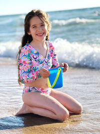 Portrait of young woman sitting at beach