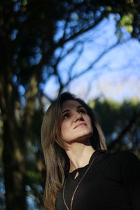 Low angle view of woman against trees