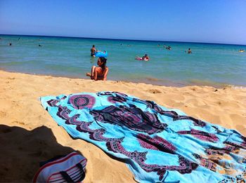 People at beach against blue sky