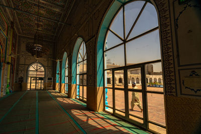 Empty railroad station platform seen through glass window