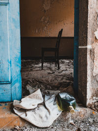 Abandoned chair against wall