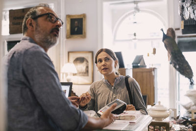 Owner with female customer at shop counter