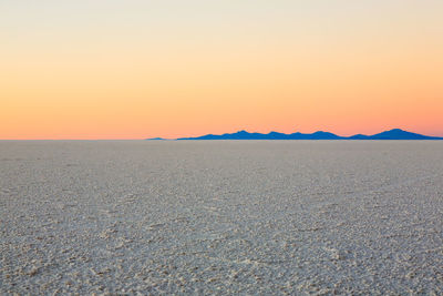 Scenic view of desert against sky during sunset