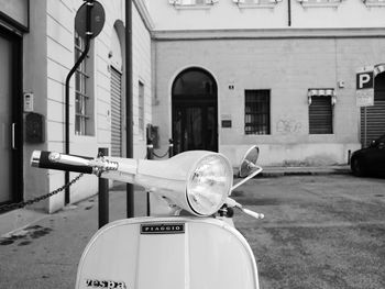 Motor scooter on road by buildings in city