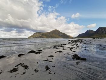 Scenic view of sea and mountains against sky