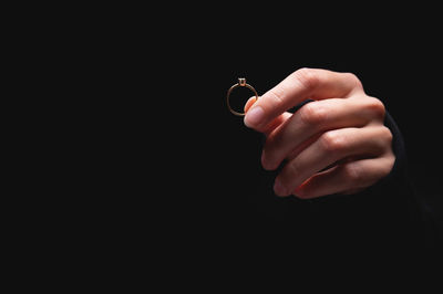 Diamond ring in a girls hand on a black background. concept of love and wedding or divorce and
