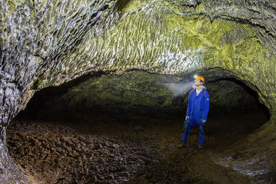 Rear view of man standing in cave