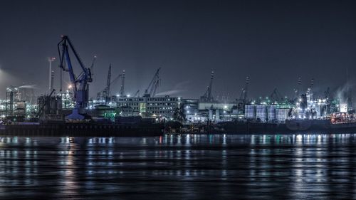 Silhouette of crane and seascape against sky