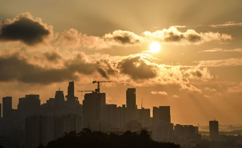 Silhouette buildings against sky during sunset