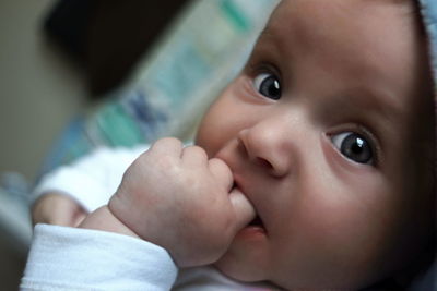 Close-up portrait of cute baby lying on bed