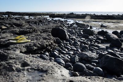 Rocks on beach against clear sky