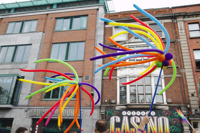 Low angle view of multi colored umbrellas hanging on building