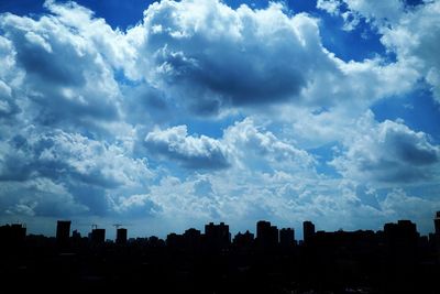 View of cityscape against cloudy sky