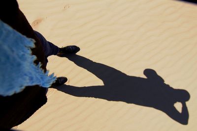 High angle view of people shadow on sand at beach