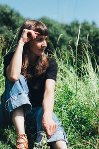 Full length of young woman sitting on field