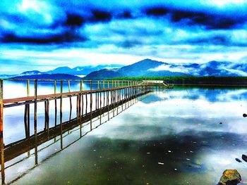 Scenic view of calm lake against cloudy sky