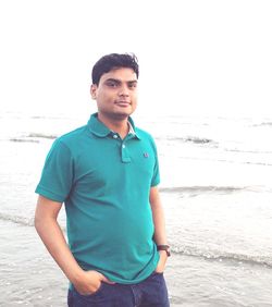 Portrait of young man standing on beach