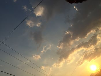 Low angle view of electricity pylon against cloudy sky