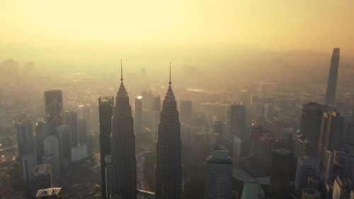 Aerial view of buildings in city during sunset