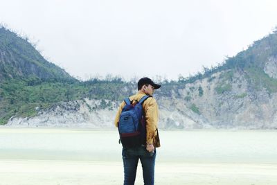 Full length of man standing on shore against sky