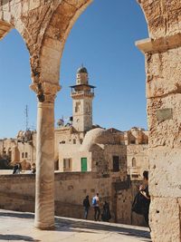 People in old building against clear sky