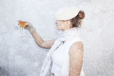 Woman holding wineglass in the snow