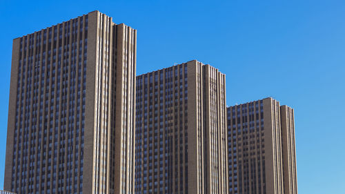 Low angle view of modern building against clear blue sky