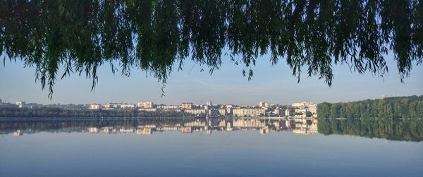 Scenic view of lake by buildings against sky