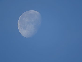 Low angle view of moon against blue sky