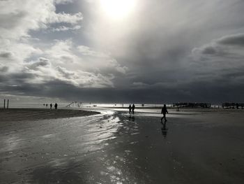 People on beach against sky