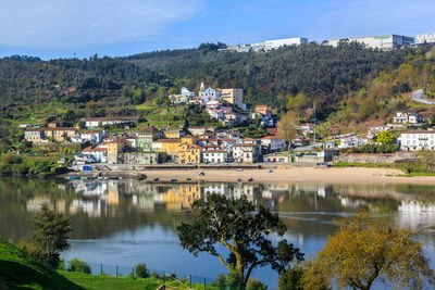 Scenic view of lake by houses against sky