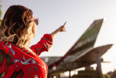 Woman pointing at sky in park