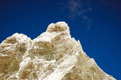 Low angle view of rocks against blue sky