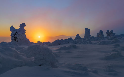 Scenic view of snowcapped mountains against sky during sunset