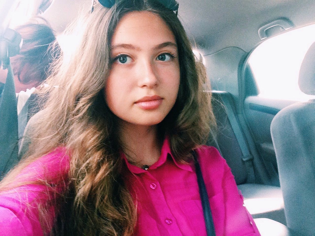 CLOSE-UP PORTRAIT OF YOUNG WOMAN IN CAR