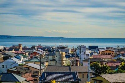 High angle view of townscape by sea against sky