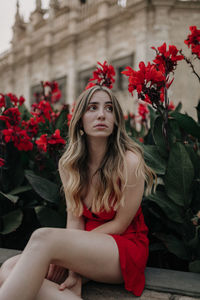 Portrait of beautiful young woman with red flower