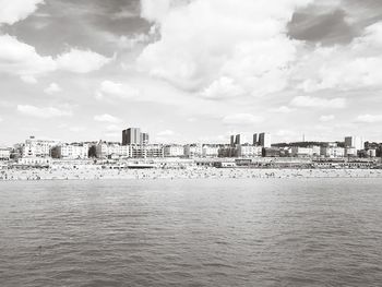 View of cityscape by sea against sky