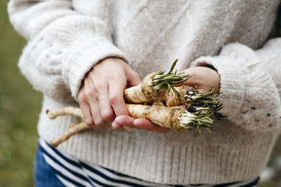 Midsection of woman holding radish