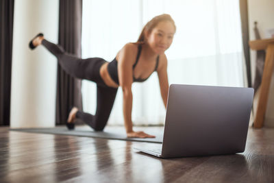 Young woman using laptop while sitting on table